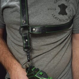 A man wearing a grey shirt and a black leather single point sling with green stitching - Grommet's Leathercraft - renaissance clothing - renaissance art clothing - renaissance era clothing - leathercraft supplies - leathercraft accessories - leathercraft store near me - quality leather craft