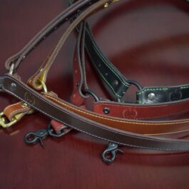 Four leather single point sling laid on a wooden table - Grommet's Leathercraft - renaissance clothing - renaissance art clothing - renaissance era clothing - leathercraft supplies - leathercraft accessories - leathercraft store near me - quality leather craft