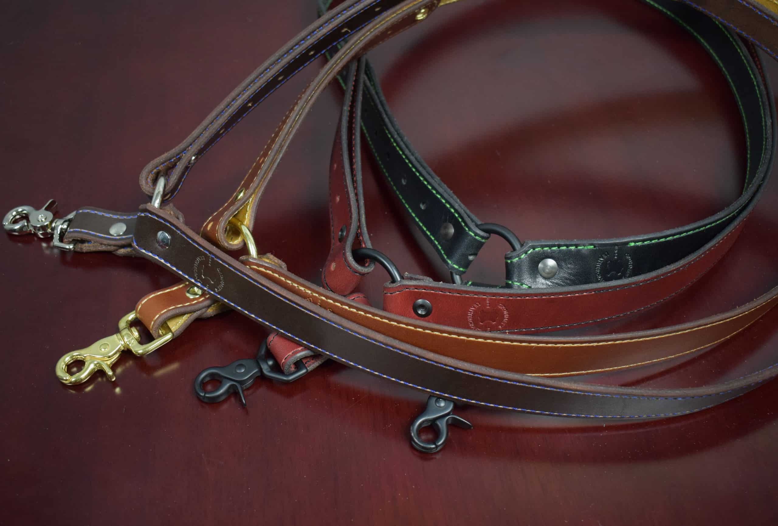 Four leather single point sling laid on a wooden table - Grommet's Leathercraft - renaissance clothing - renaissance art clothing - renaissance era clothing - leathercraft supplies - leathercraft accessories - leathercraft store near me - quality leather craft