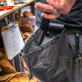 A person holding a Waxed Canvas Bushcraft Foraging/Dump Pouch in their hand.