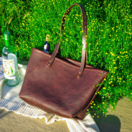 a dark brown bison tote on a picnic blanket