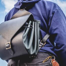A man carrying a Leather Cinch Top Backpack on his back.