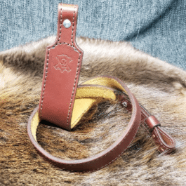 A light brown Handmade Leather Cobra Rifle Sling without attachments laid on a fur cloth - Grommet's Leathercraft - renaissance clothing - renaissance art clothing - renaissance era clothing - leathercraft supplies - leathercraft accessories - leathercraft store near me - quality leather craft