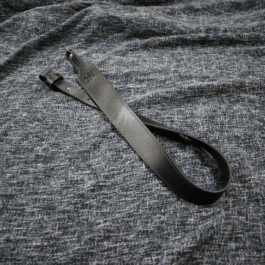 A black Handmade Leather Cobra Rifle Sling without attachments laid on a cloth - Grommet's Leathercraft - renaissance clothing - renaissance art clothing - renaissance era clothing - leathercraft supplies - leathercraft accessories - leathercraft store near me - quality leather craft