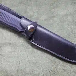 A Benchmade Nimravus/Protagonist knife with a handmade leather sheath in black on a table.
