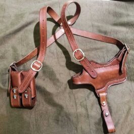 A shoulder holster for full size 1911 laying on a bed.