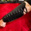 a Mirkwood Archers Vambrace with black leather straps on a red blanket.