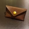 brown business card wallet with a button on top of a table - renaissance clothing - renaissance clothing men - renaissance clothing women - renaissance clothing near me - renaissance costume ideas - sword baldrics - baldrics leather - baldric belt