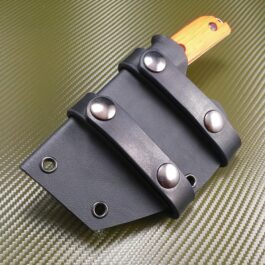 a Kydex sheath for the Benchmade Nestucca Cleaver with a wooden handle on a green surface.