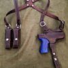 a brown Leather Shoulder Holster for the Beretta Px4 Storm and a blue plastic gun.