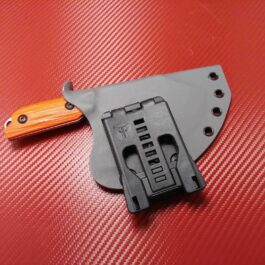 A close up of the Kydex Sheath for the Benchmade Nestucca Cleaver on a red surface.