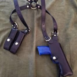 Leather Shoulder Holster for the Beretta Px4 Storm and a gun on a bed.