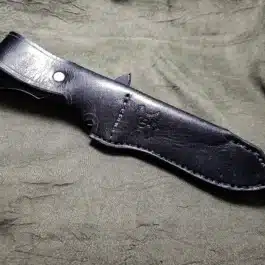 A Leather Sheath for the Benchmade Fixed Contego laying on top of a green cloth.