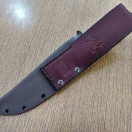 A Ka Bar Fighting knife with a Kydex sheath on a table.