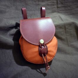 A large sporran belt pouch laying on a bed.