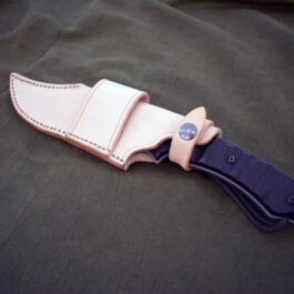 A TOPs Longhorn Bowie knife with a Handmade Leather Sheath attached to it.