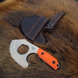 A Leather Scout Sheath for the Benchmade Nestucca Cleaver and a Benchmade Nestucca Cleaver laying next to each other.