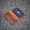 A Handmade Leather Passport Wallet with a US passport sticking out of it.