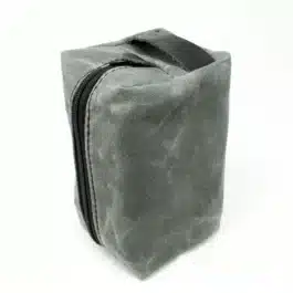 A gray Canvas Dopp Kit/Toiletry Bag with a black zipper on a white background.