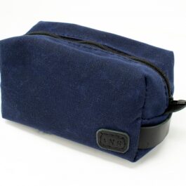 A blue Canvas Dopp Kit/ Toiletry Bag sitting on top of a white table.