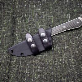 A Horizontal Kydex Sheath for the Chris Reeve Nyala that is laying on a cloth.
