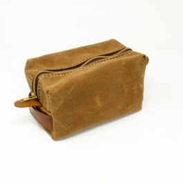 A Canvas Dopp Kit/Toiletry Bag sitting on top of a white table.