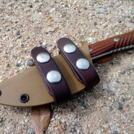 A Chris Reeve Nyala knife laying on the ground with a Horizontal Kydex Sheath.