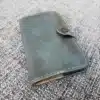 green Leather Field Notes Cover laid on a cloth - renaissance clothing - renaissance clothing men - renaissance clothing women - renaissance clothing near me - renaissance art clothing - renaissance era clothing - renaissance costume ideas
