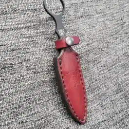 a red Handmade leather Sheath for the Benchmade SOCP Dagger with a black handle.