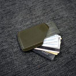 A pile of Kydex wallets sitting on top of a carpet.