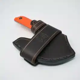 A Leather Scout Sheath for the Benchmade Nestucca Cleaver with an orange handle on a white surface.