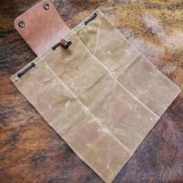 A Waxed Canvas Bushcraft Foraging/Dump Pouch with a leather tag attached to it.