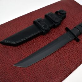A Leather Sheath for the Ka Bar Tanto Fighting Knife sitting on top of a red mat.