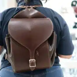 A person with a Leather Cinch Top Backpack on their back.
