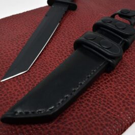 A Leather Sheath for the Ka Bar Tanto Fighting Knife is laying on top of a leather case.