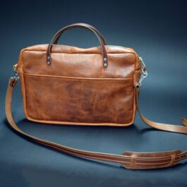 A Bison Leather Briefcase Satchel sitting on top of a blue surface.