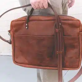 A person holding a Bison Leather Briefcase Satchel in their hand.
