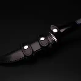 A Handmade Leather Sheath for the Buck 119 on a black surface.