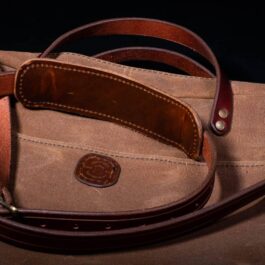 A tan Waxed Canvas Briefcase Satchel with a brown leather strap.