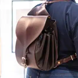 A man carrying a Leather Cinch Top Backpack on his back.