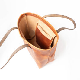 A Horween Leather Tote Bag with a book in it.