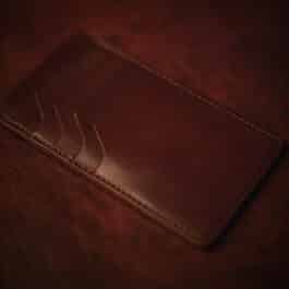 An ID Slot leather Bifold Wallet sitting on top of a table.