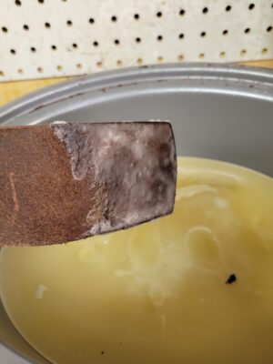 a metal bowl with a brown substance in it.