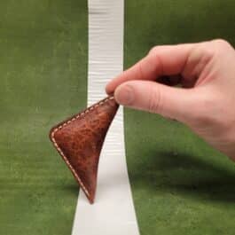 A hand is holding a NFL Leather Finger Football.