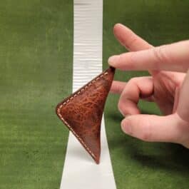 A hand is holding an NFL Leather Finger Football.