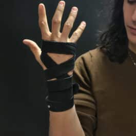 A woman holding her hand with Artisans Bindings on her wrist.