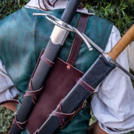 A man in a Monster Hunter Sword Carrier costume holding a sword.