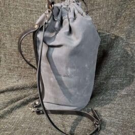 A Waxed Canvas Duffel Bag sitting on top of a couch.