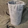 a Waxed Canvas Duffel Bag sitting on top of a floor next to a leash.
