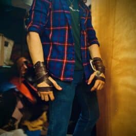 a man wearing a plaid shirt and leather gloves.